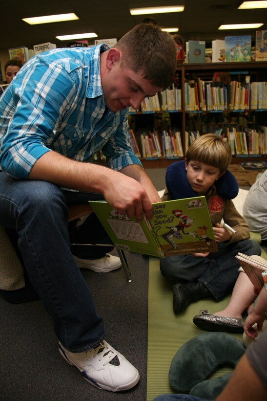 Lance Cpl. Brandon C. Fox reads one of the many works of Dr. Seuss with a student of Bangert Elementary School during the Single Marine Program’s participation in Bangert’s Reading Night, Nov. 30. Fox and seven other Marines helped read to students and teach them to make origami.