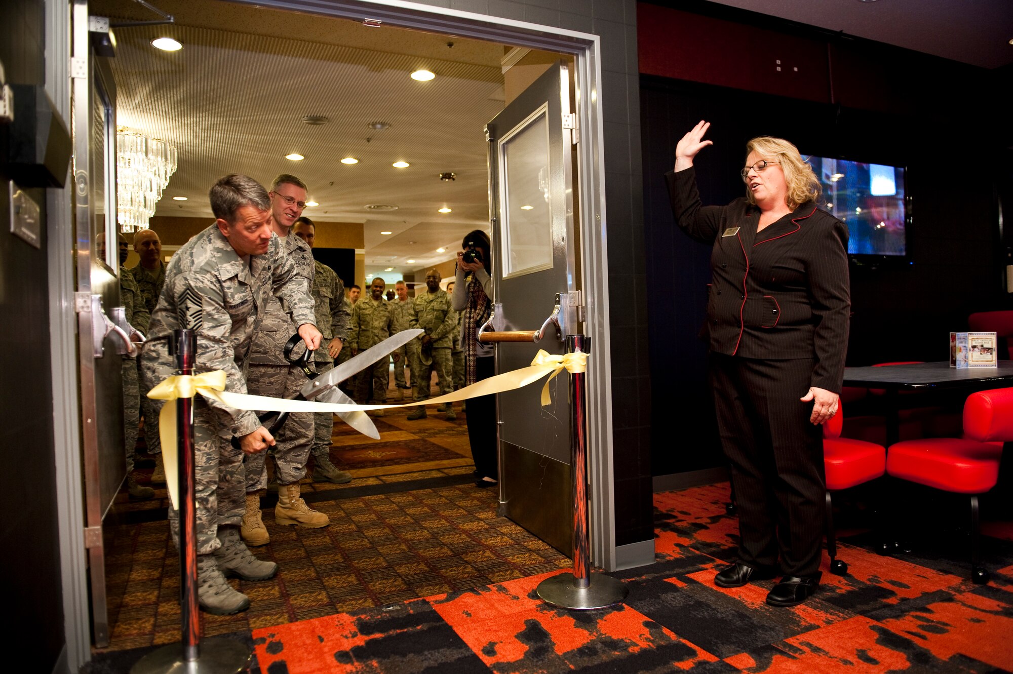 Chief Master Sgt. Russell Hastings, 35th Fighter Wing command chief, cuts the ceremonial ribbon, Nov. 30, 2010, alongside Col. David Wiegand, 35th Mission Support Group commander and Erin Robinson, assistant Collocated Club manger, during the enlisted Sports Bar’s grand re-opening at Misawa Air Base, Japan. The $90,000 renovation project took about one month to complete, with the installation of new carpet, tiling, tables and chairs and an upgraded sound system. (U.S. Air Force photo by Staff Sgt. Samuel Morse/Released)