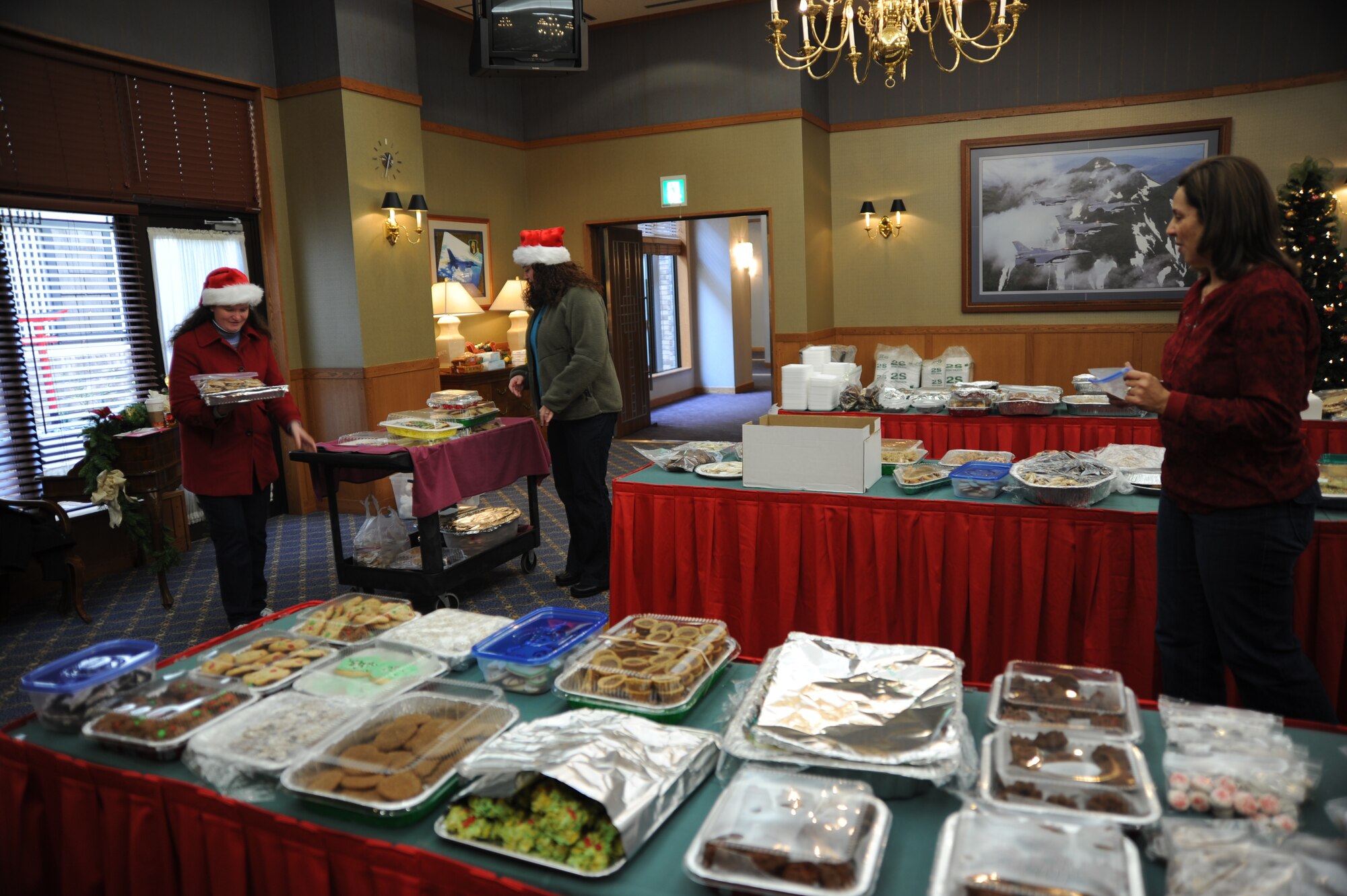 Misawa Air Base, Japan -- Karen Bigelow left, and Andrea Leon, center, transport a load of cookies as Kelli Wimmer prepares to count them during the annual Misawa Cookie Caper here, 1 Dec 2010. Each year, volunteers ask the Misawa community to bake sweets for distribution to single and unaccompanied service members on the base. The Cookie Caper is just one of many traditions observed at Misawa Air Base during the holiday season. (U.S. Air Force photo by Captain Darrick B. Lee/released.)
