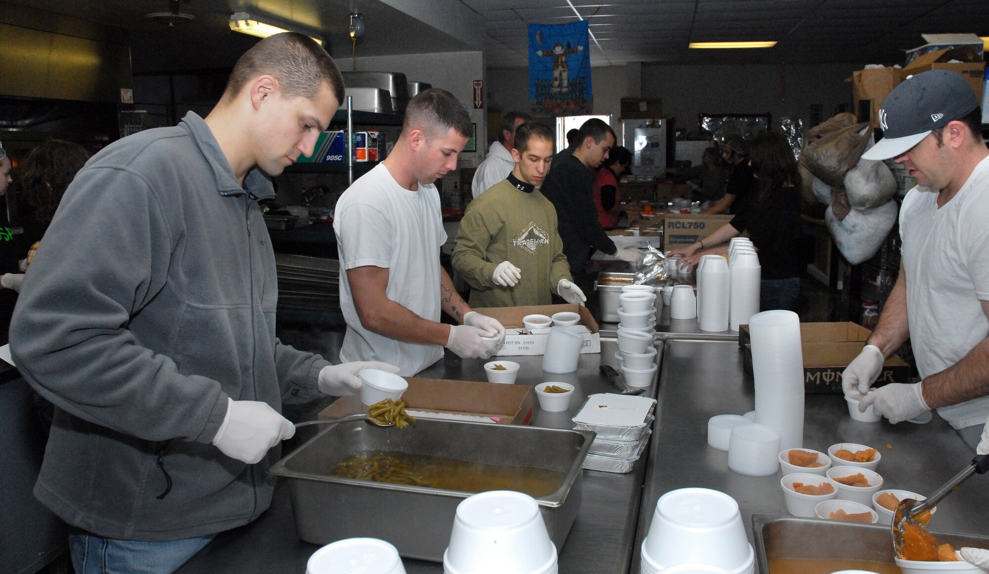 Malmstrom Airmen portion green beans and sweet potatoes for Thanksgiving meals at the Great Falls Meals on Wheels kitchen Nov. 25. The Airmen helped prepare, package and deliver 320 meals to elderly and less fortunate members of the local community. (U.S. Air Force photo/Staff Sgt. Dillon White)