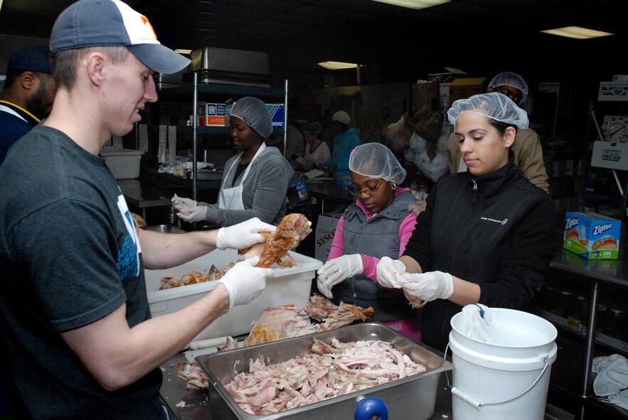 From left, Airman 1st Class Anel Mehmedovic, 341st Force Support Squadron personnelist, Staff Sgt. Latosha Tibbs, 341st FSS NCO in charge of career development, Airman 1st class Kay-Ann Wright, 341st FSS personnelist and Airman 1st Class Chere Ward, 341st FSS personnelist, debone turkey at Great Falls Meals on Wheels Nov. 24 in preperation for Operation Thanksgiving. (U.S. Air Force photo/Staff Sgt. Dillon White)
