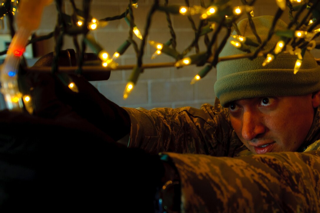 ELLWORTH AIR FORCE BASE, S.D. - Tech. Sgt. Joseph Garcia, volunteers some time to attach more lights to the Ellsworth AFB float Nov. 23. He and two other volunteers finished the float to ensure it was ready take part in the Festival of Lights Parade held in Rapid City, S.D. Sgt. Garcia is the 28th Civil Engineer Squadron NCO in charge of technical support. (U.S. Air Force photo/Tech. Sgt. Nathan Gallahan)