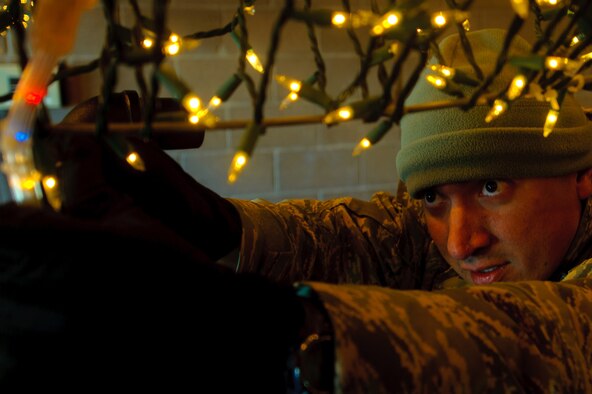ELLWORTH AIR FORCE BASE, S.D. - Tech. Sgt. Joseph Garcia, volunteers some time to attach more lights to the Ellsworth AFB float Nov. 23. He and two other volunteers finished the float to ensure it was ready take part in the Festival of Lights Parade held in Rapid City, S.D. Sgt. Garcia is the 28th Civil Engineer Squadron NCO in charge of technical support. (U.S. Air Force photo/Tech. Sgt. Nathan Gallahan)