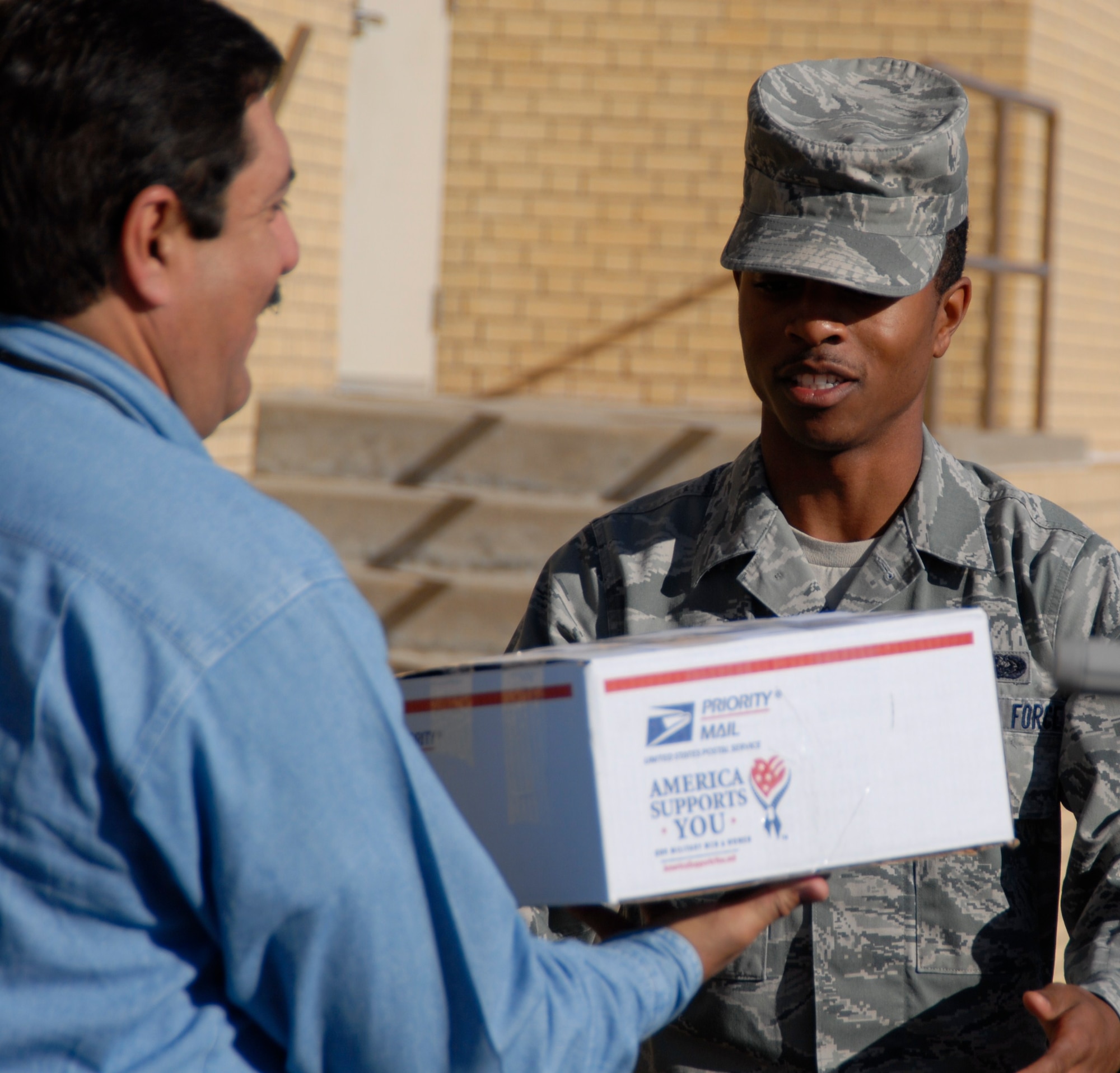 GOODFELLOW AIR FORCE BASE, Texas - Chaplain Scott Jimenez, West Texas VA Medical Center, hands a care package to Airman 1st Class Will Campbell, 17th Communications Squadron during the Operation Soldier Holiday program drive, Nov. 29 at Big Spring, Texas. (U.S. Air Force photo/Airman 1st Class Anne Gathua)


