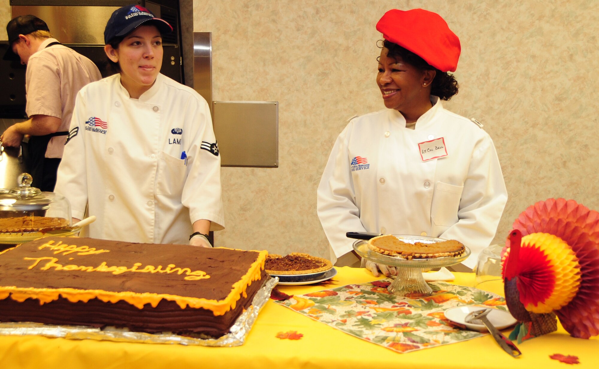 ELLSWORTH AIR FORCE BASE, S.D. -- (Right to left) Lt. Col. Oledia Bell, 28th Bomb Wing head chaplain, and Airman 1st Class Tiffany Lamb, 28th Force Support Squadron food service technician, wait to serve dessert to Airmen during the base's Thanksgiving Day lunch, Nov. 25.  Several senior leaders helped serve the holiday meal at the Bandit Inn. (U.S. Air Force photo/Senior Airman Anthony Sanchelli)