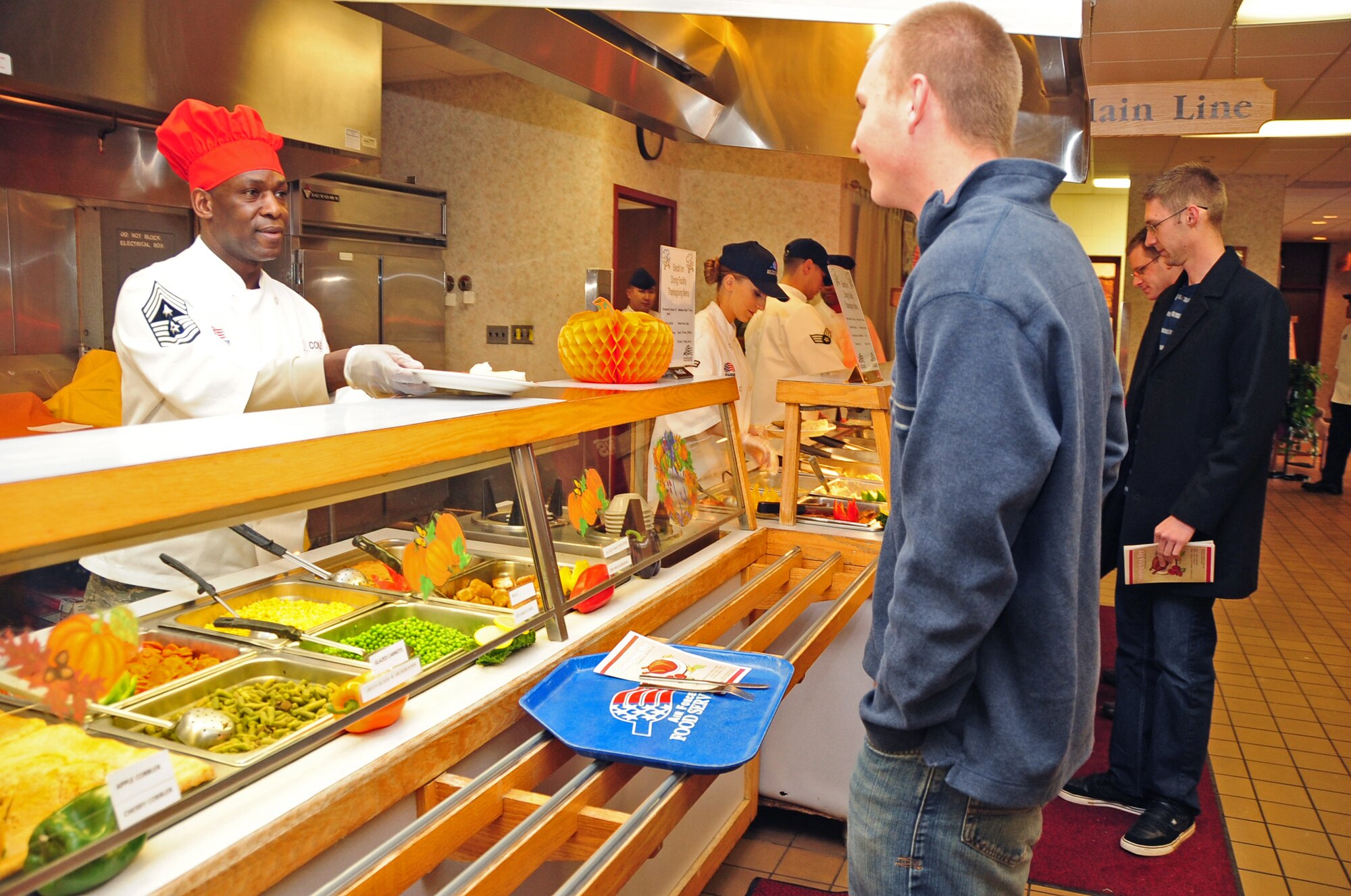 ELLSWORTH AIR FORCE BASE, S.D. -- Chief Master Sgt. Clifton Cole, 28th Bomb Wing command chief, serves food to Airman 1st Class Kenneth Kahler, 28th Aircraft Maintenance Squadron crew chief, during the base's Thanksgiving Day lunch, Nov. 25.  Several senior leaders, including the 28th Bomb Wing Commander Col. Jeffrey Taliaferro and the Mission Support Group Commander Col. Trent Edwards, teamed up to serve a holiday meal for Airmen at the Bandit Inn. (U.S. Air Force photo/Senior Airman Anthony Sanchelli)