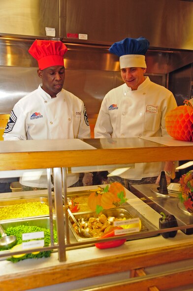 ELLSWORTH AIR FORCE BASE, S.D. -- (Right to left) Col. Jeffrey Taliaferro, 28th Bomb Wing commander, and Command Chief Master Sgt. Clifton Cole, 28th BW command chief, prepare to serve customers a holiday meal with all the trimmings during the base's Thanksgiving Day lunch, Nov. 25.  Several senior leaders served food to raise the morale of single Airmen who may not families here to share the holiday with. (U.S. Air Force photo/Senior Airman Anthony Sanchelli)