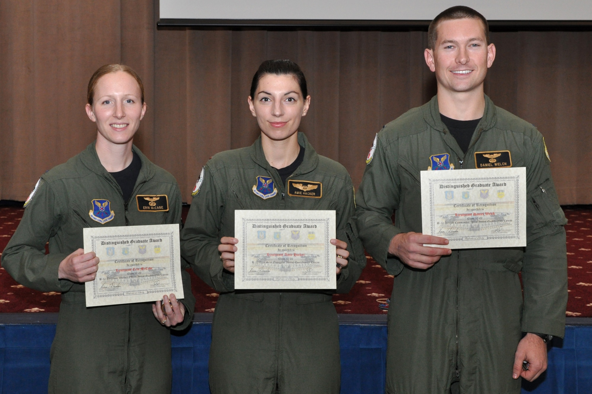 Distinguished Graduates for Class 10-02, 1st Lieutenant Erin McCabe, B-52 Electronic Warfare Officer Initial Qualification Course, 2nd  Lieutenant Amie Hacker, B-52 Dual Seat Navigator Initial Qualification Course, and 1st Lieutenant Daniel Welch, B-52 Aircraft Commander/Pilot Initial Qualification Course, pose for a group photo during graduation ceremonies in Hoban Hall at Barksdale Air Force Base, La., Nov 29, 2010. Graduates covered several aspects of B-52H Stratofortress operations during their training, which lasted approximately two years. Twenty-four students graduated from Class 10-02 at the 93rd Bomb Squadron's Formal Training Unit at Barksdale AFB and will now report for duty to squadrons throughout the B-52 community. (U.S. Air Force photo/Tech. Sgt. Jeff Walston)