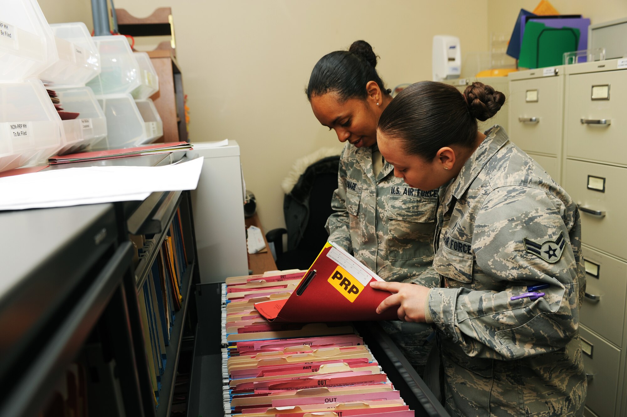 MINOT AIR FORCE BASE, N.D. -- Airman 1st Class Frances Jimenez, 5th Medical Operations Squadron mental health technician, and Airman 1st Class Awotash Asmare, 5th MDOS mental health technician, cycle through the personnel reliability program files in the record room here Nov. 23. The mental health clinic at the 5th Medical Group supports the men and women of the 5th Bomb Wing and 91st Missile Wing making sure they are mentally ready for duty. (U.S. Air Force photo/Airman 1st Class Aaron-Forrest Wainwright)