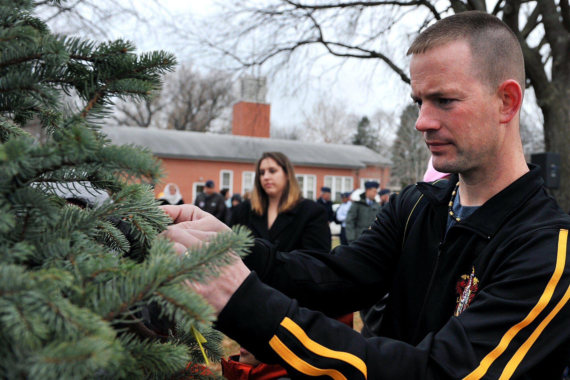 OFFUTT AIR FORCE BASE, Neb. - Staff Sgt. Ryan Paul, 55th Security Forces Squadron, places a ribbon on the hero tree during a special dedication ceremony at Offutt's new Hero Park outside the SAC Memorial Chapel Nov. 29. Personnel from the Offutt community will be able to gather at the hero tree to meditate, reflect on and pray for their deployed love ones. U.S. Air Force photo by Charles Haymond (Released)