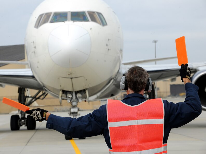 MOODY AIR FORCE BASE, Ga.--  Herbert Smith, contracted civilian worker, ushers in a Boeing 757 aircraft that recently carried the 824th Base Defense Squadron to their deployed location. Most of the 824th BDS will be deployed to Southwest Asia. (U.S. Air Force photo/Airman 1st Class Benjamin Wiseman)(RELEASED)