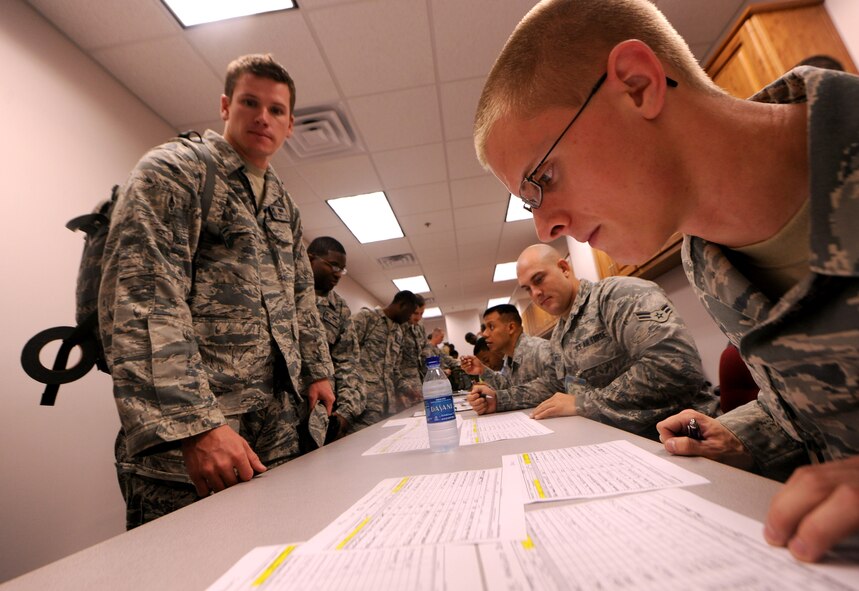 MOODY AIR FORCE BASE, Ga.-- Airman 1st Class Tanner Hundley, 23rd Logistics Readiness Squadron fuels technician, checks for a name on the personnel roster as Tech. Sgt. Joshua Allen, 824th Base Defense Squadron squad leader, is processed through the line during a recent deployment. Each member from the 824th BDS had to go through the processing line before being allowed to depart. (U.S. Air Force photo/Airman 1st Class Benjamin Wiseman)(RELEASED)