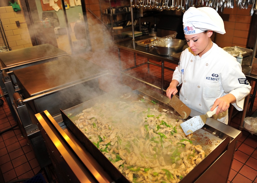 MINOT AIR FORCE BASE, N.D. -- Senior Airman Victoria Kemper, 5th Force Support Squadron dinner shift leader, prepares food for Airmen’s enjoyment at the Dakota Inn Dining Facility here Nov. 23. Airmen from the 5th FSS will provide support in preparing the holiday feast for the Day of Love, an annual event providing a home cooked meal to Team Minot’s elderly for the Thanksgiving holiday. (U.S. Air Force photo/Senior Airman Michael J. Veloz)