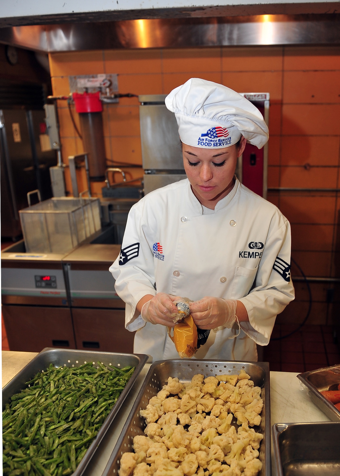 MINOT AIR FORCE BASE, N.D. -- Senior Airman Victoria Kemper, 5th Force Support Squadron dinner shift leader, prepares food for Airmen’s enjoyment at the Dakota Inn Dining Facility here Nov. 23. Airmen from the 5th FSS will provide support in preparing the holiday feast for the Day of Love, an annual event providing a home cooked meal to Team Minot’s elderly for the Thanksgiving holiday. (U.S. Air Force photo/Senior Airman Michael J. Veloz)