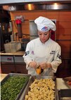 MINOT AIR FORCE BASE, N.D. -- Senior Airman Victoria Kemper, 5th Force Support Squadron dinner shift leader, prepares food for Airmen’s enjoyment at the Dakota Inn Dining Facility here Nov. 23. Airmen from the 5th FSS will provide support in preparing the holiday feast for the Day of Love, an annual event providing a home cooked meal to Team Minot’s elderly for the Thanksgiving holiday. (U.S. Air Force photo/Senior Airman Michael J. Veloz)