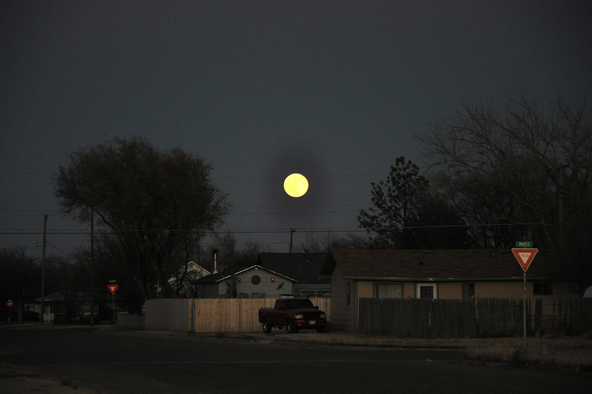 A full moon rises over a neighborhood on the western edge of the Oklahoma panhandle, Nov. 21, 2010. Although the Northern areas of Texas, including the panhandle of Oklahoma are mostly rangeland for cattle, wheat, cotton, corn and sugar are the most common food crops grown in the area. (Courtesy photo/Jeff Walston)