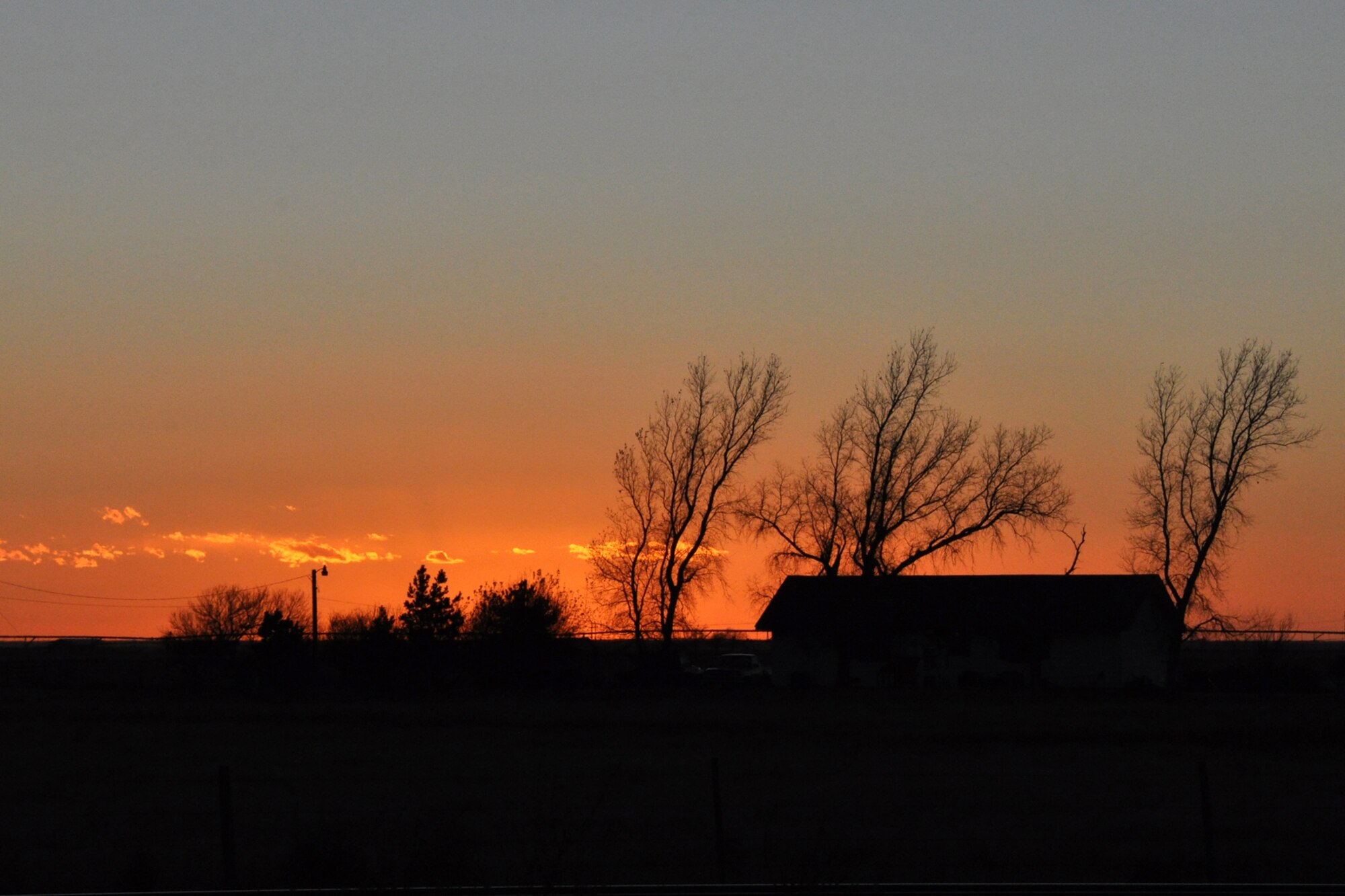 The Sun sets behind a farm house on the western edge of the Oklahoma panhandle, Nov. 21, 2010. Although the Northern areas of Texas, including the panhandle of Oklahoma are mostly rangeland for cattle, wheat, cotton, corn and sugar are the most common food crops grown in the area. (Courtesy photo/Jeff Walston)
