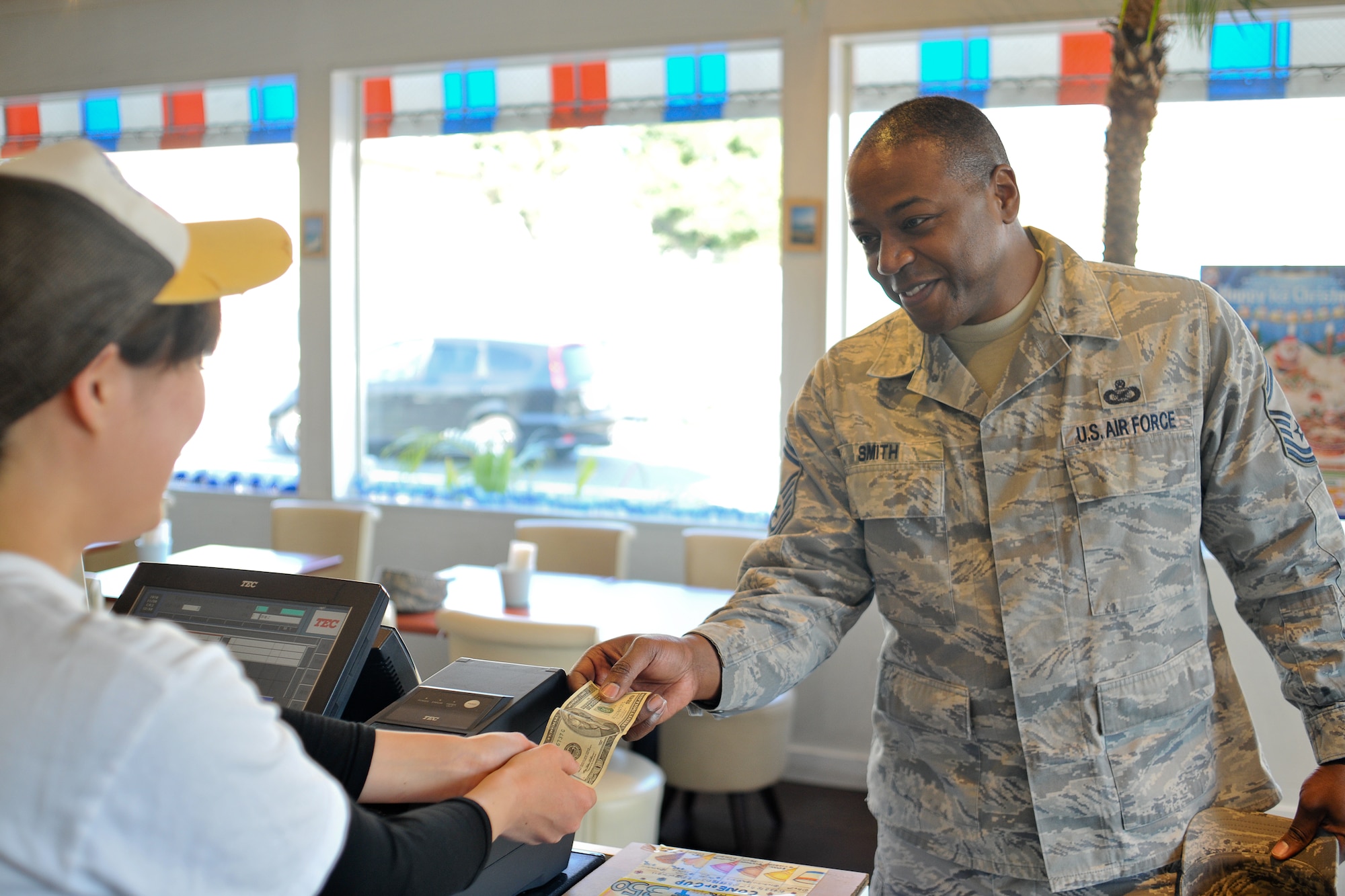 FUSSA, Japan -- Senior Master Sgt. Valarry Smith, Armed Forces Network Tokyo, makes a purchase in a Japanese business using American dollars.  When you go shopping on Route 16, you can use U.S. dollars for payment, if you see a "Dollar OK" sticker in front of the store. (U.S. Air Force photo/Osakabe Yasuo)