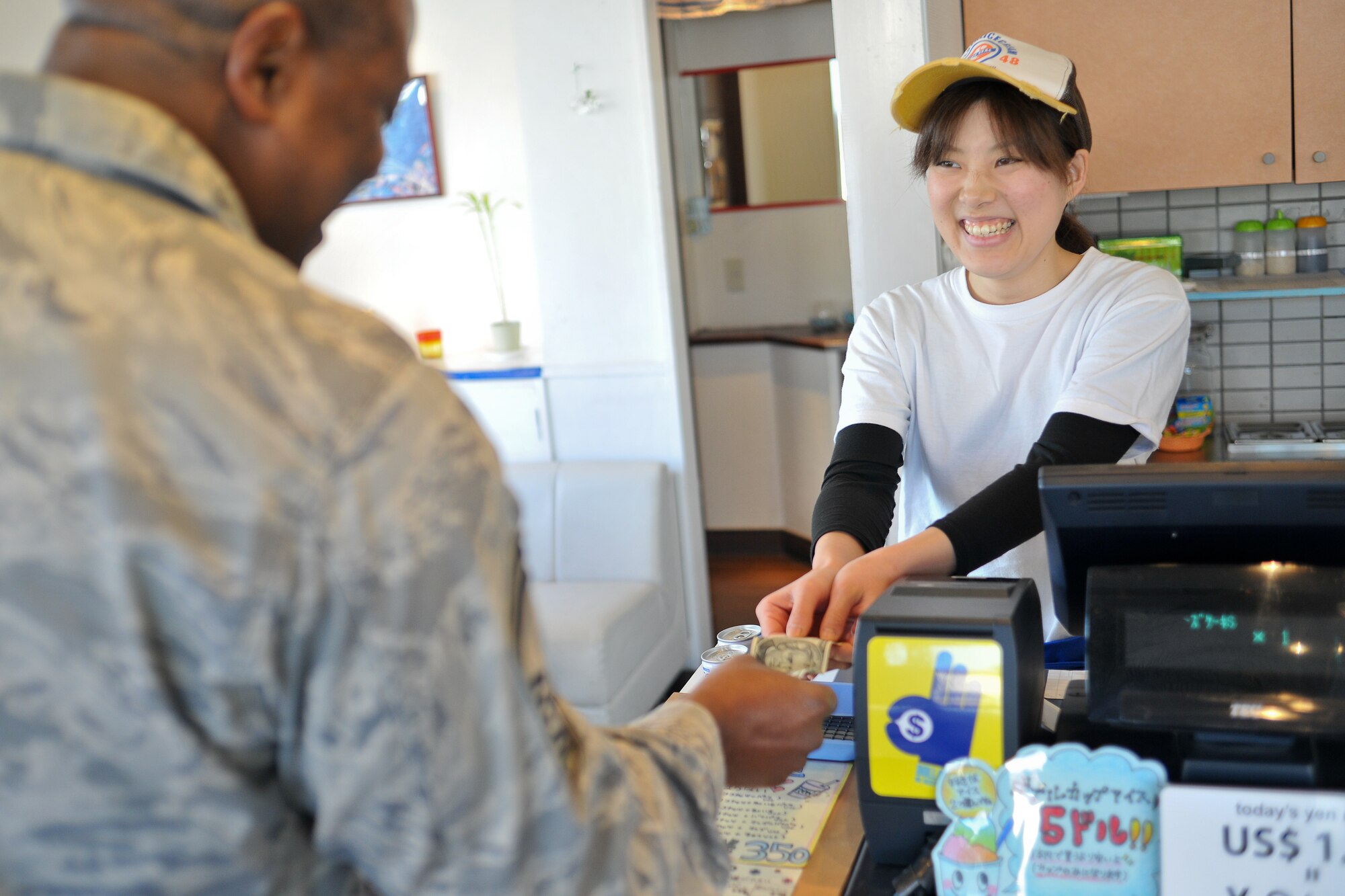 FUSSA, Japan -- Senior Master Sgt. Valarry Smith, Armed Forces Network Tokyo, makes a purchase in a Japanese business using American dollars. When you go shopping on Route 16, you can use U.S. dollars for payment, if you see a "Dollar OK" sticker in front of the store. (U.S. Air Force photo/Osakabe Yasuo)