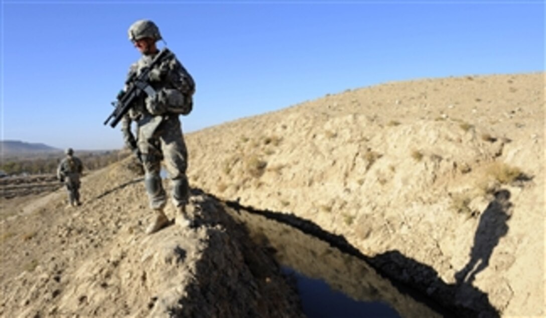 U.S. Army Spc. Joseph Murphy (right) and Sgt. David Shanahan (left) secure a section of canal during a site survey near Highway 1 in Zabul province, Afghanistan, on Nov. 27, 2010.  Murphy and Shanahan are assigned to Zabul Provincial Reconstruction Team's security force.  