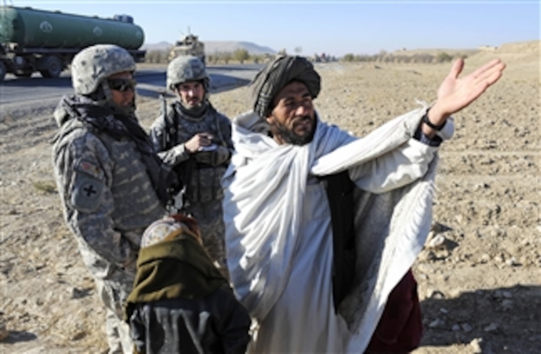 U.S. Army 1st Lt. Raymond Gobberg (2nd from right), the information operations officer for the Zabul Provincial Reconstruction Team, talks with a village elder during a canal site survey near Highway 1 in the Zabul province of Afghanistan on Nov. 27, 2010.  During the visit the team discussed problems facing the village and how the local government receives information.  