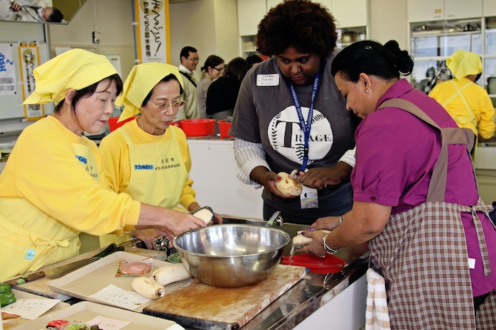 Local Japanese nationals teach classmates how to prepare lotus root, a popular food throughout Iwakuni and Japan, in a cooking class provided by the Cultural Adaptation Program here Dec. 1. Approximately 10 women participated in making lotus root pizza dough, sauteed lotus root and lotus root salad. Participants prepared each meal in groups of two or three and were helped by at least one other Japanese national.