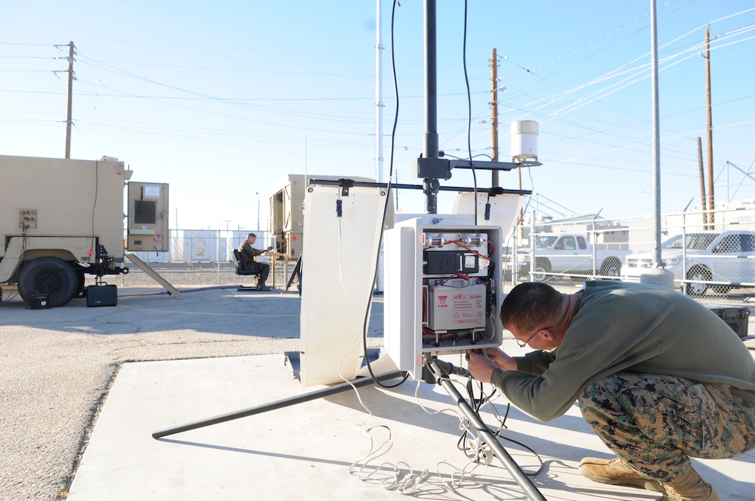 Sgt. Dustin Jones, left, station forecaster, checks information coming in from the remote transmitter while Lance Cpl. Charles Eichler, station weather equipment maintainer, tightens the wire connections on another remote transmitter at the Marine Corps Air Station in Yuma, Ariz., Nov. 30, 2010. The transmitters are part of the new Meteorological Mobile Facility Next Generation Replacement System which consists of a humvee, trailer, two remote transmitters, one local transmitter, radar and the ability to tap into weather satellites and is due to replace old, static equipment. The system is the first in the Corps and Yuma is being used as a test bed before it is used throughout the Corps.