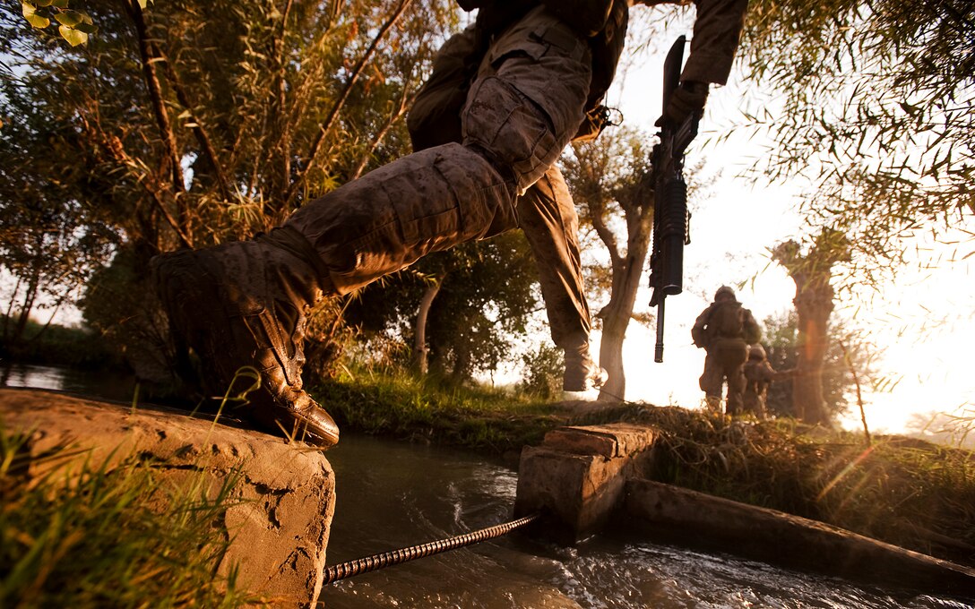 Lance Cpl. Timothy Kinkade, a team leader with the Combined Action Company, 3rd Battalion, 3rd Marine Regiment, jumps across a stream in Gowragi, Afghanistan, while on patrol during a clearing operation, Oct. 1, 2010. The clearing operation was followed by a sustained presence in the area. Kinkade is from Philadelphia.