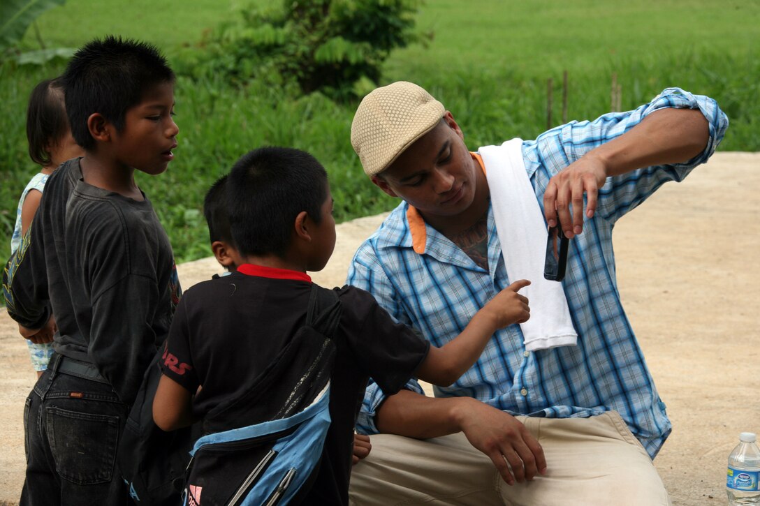 Panamanian children play with Cpl. Matthew Faus' cell phone at a community relation project in Chiriqui Grande, Panama, Oct. 5, 2010. Faus, a native of Reading, Pa., is one of three civil affairs Marines from II Marine Expeditionary Force 10th Marines Civil Affairs Detachment who deployed to Latin America and the Caribbean with Special-Purpose Marine Air-Ground Task Force Continuing Promise 2010.
