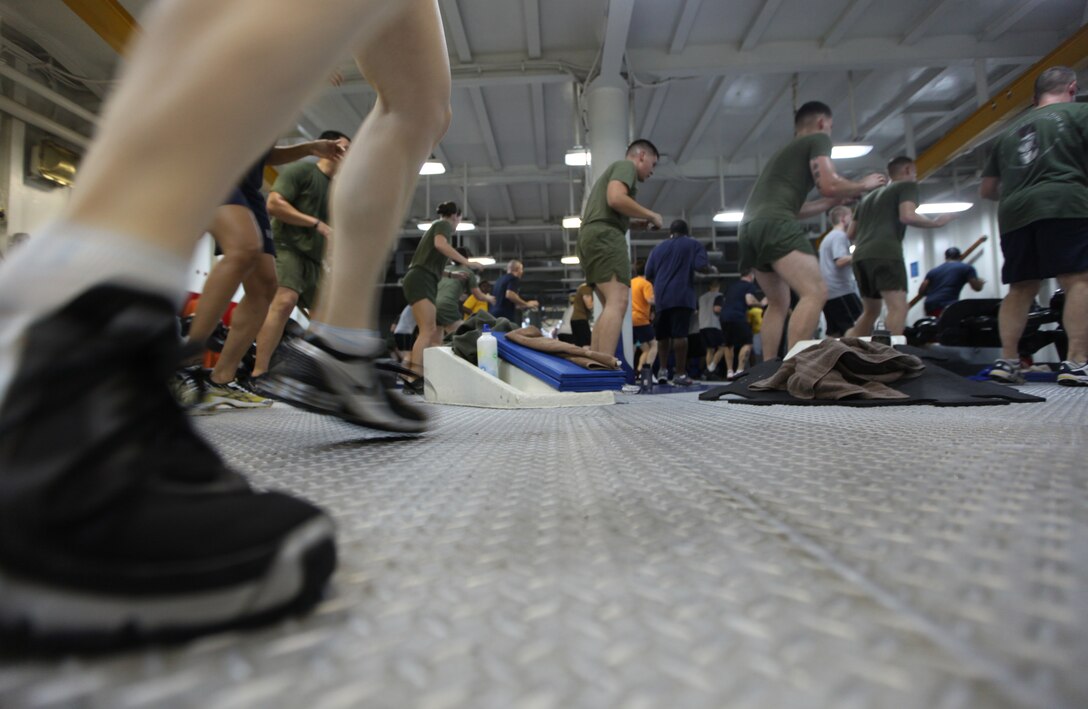 Marines and sailors aboard USS Kearsarge perform exercises during a cardio class in the ships foc'sle while in the U.S. Navy 5th Fleet Area of Responsibility, Oct. 1, 2010. 26th MEU is currently embarked aboard the ships of Kearsarge Amphibious Ready Group operating in the U.S. Navy 5th Fleet Area of Responsibility.