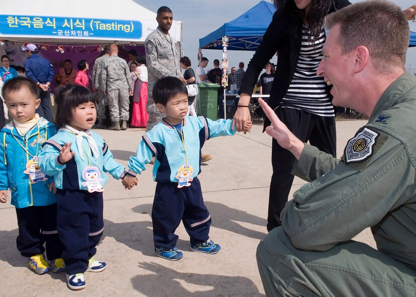 KUNSAN AIR BASE, Republic of Korea -- Col. John Dolan, 8th Fighter Wing commander, waves to local Korean children during the Kunsan Air Base Open House and Gunsan Appreciation Day here Oct. 1, 2010. The base opened its doors to the local community and held events including an F-16 Fighting Falcon fly-by, Korean dance performances, static displays, organizational booths, military working dog demonstrations, aircraft munitions-loading competitions, music and more. (U.S. Air Force photo/Senior Airman Ciara Wymbs)