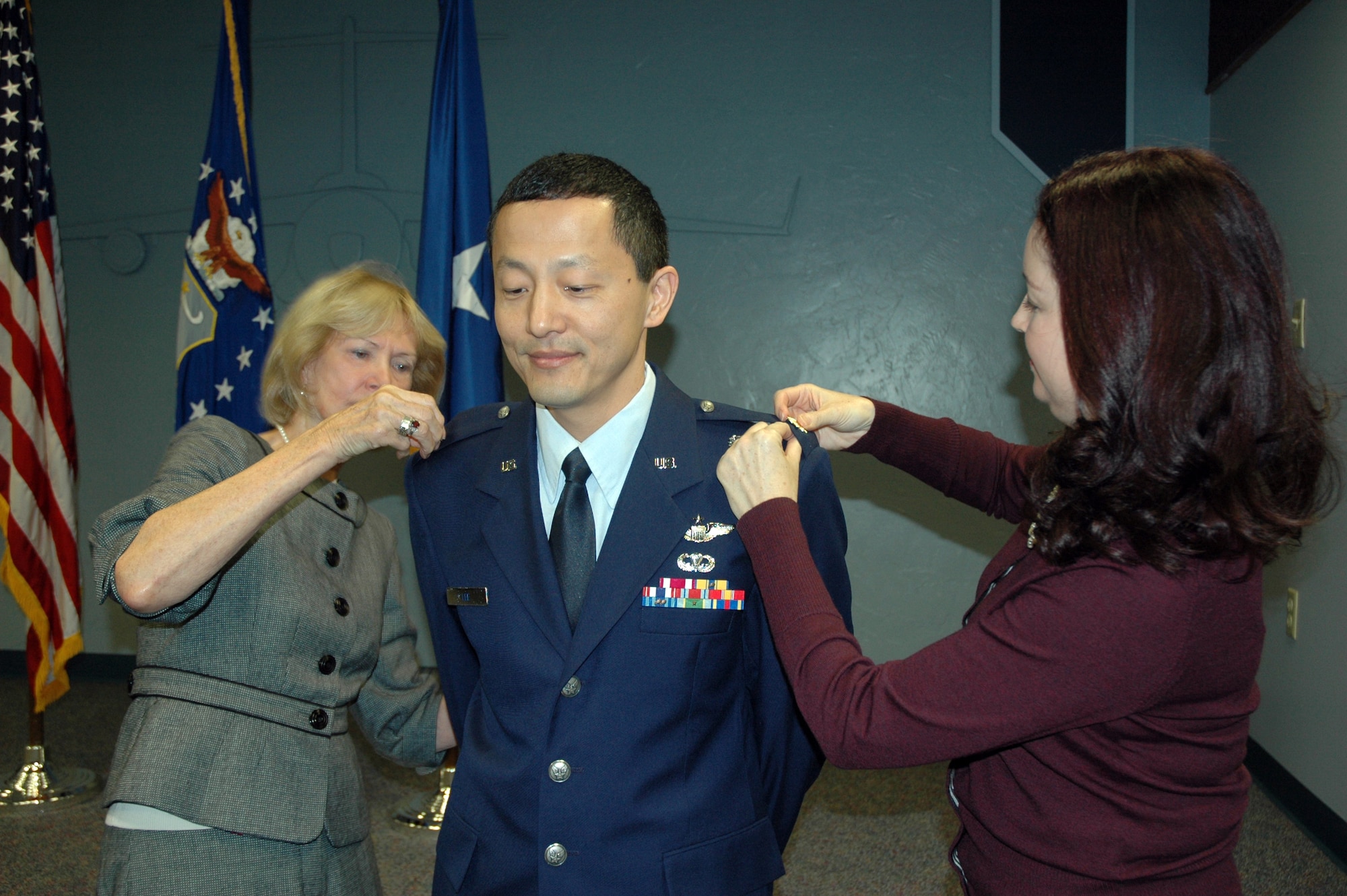 JOINT BASE LEWIS-MCCHORD, Wash.- Maj. Steven Lee, 446th Airlift Wing executive, has his new rank of lieutant colonel pinned on by his mother-in-law Jean Higgins (left) and wife Suzanne Lee, during a ceremony Oct. 1. (U.S. Air Force photo/2nd Lt. Denise Hauser)  