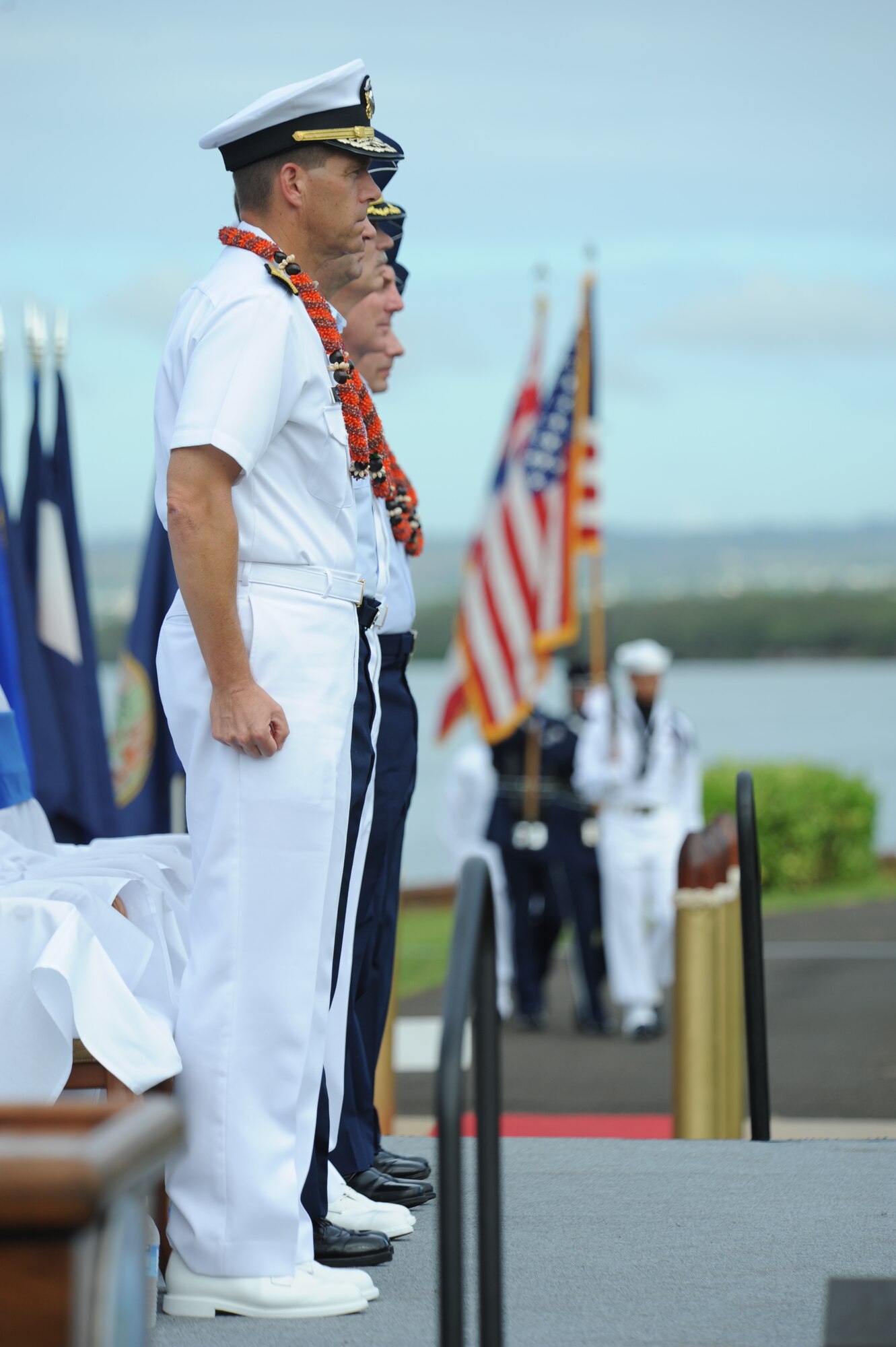 The official party of the Full Operational Capability Commemoration Ceremony stand at attention as the colors are advanced Oct. 1 at the Missing Man Formation Memorial at Aloha Aina Park. The FOC ceremony marks the joining of two historic military installations, Naval Station Pearl Harbor and Hickam Air Force Base. (U.S. Air Force photo by Staff Sgt. Nathan Allen)