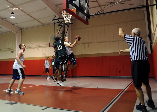 Sailors drive to the basket for a lay-up during the Commander's Cup basketball game at the Joint Base Charleston-Weapons Station, S.C., fitness center Sept. 30, 2010. The competition for the Commander's Cup began Sept. 17 and was comprised of numerous sporting events. Challenges included golf, volleyball, basketball, and a relay run, bike and swim, all held in celebration of JB CHS reaching full operational capability as Air Force and Navy bases merged Oct. 1. The game was held between Air Force and Navy teams. The Navy team won 57-55. (U.S. Air Force photo/Senior Airman Timothy Taylor)