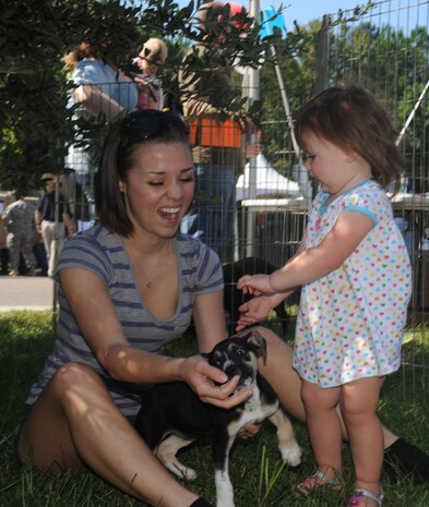 Kristen Bruce and Lillie Ross play with a rowdy puppy at the Combined Federal Campaign tent on Joint Base Charleston-Weapons Station, S.C., Oct. 1, 2010, during the open house event in commemoration of JB CHS's full operational capability. The event was open to the entire base and local community. Four puppies from the Animal Society of Charleston were the highlight of the CFC tent. The Animal Society is one of the many organizations that the CFC sponsors. Ms. Bruce is a dental assistant with the 628th Medical Group and Lillie is the daughter of Gatlin Ross, a nuclear operations student at the Weapons Station. (U.S. Air Force photo/Airman 1st Class Lauren Main)