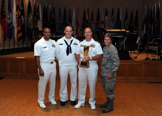Air Force Col. Martha Meeker presents the Commander's Cup to members of the Naval Nuclear Power Training Command at the Red Bank Club on Joint Base Charleston-Weapons Station, S.C., Oct. 1, 2010. The NNPTC athletes finished the Commander's Cup with the most points in a series of sporting events leading up the inauguration of Joint Base Charleston. The NNPTC won with a final score of 68, a slim lead over the second place team, the 14th Airlift Squadron, with their score of 66. (U.S. Air Force photo/Senior Airman Timothy Taylor)