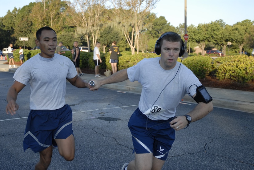 Air Force Tech. Sgt. Stan Hipolito passes the baton to Air Force 1st. Lt. Ryan Peake to start the second leg of the Commander's Cup relay race on Joint Base Charleston, S.C., Oct. 1, 2010.  This event and other festivities were held in celebration of JB CHS reaching full operational capability as Charleston's Air Force and Navy installations merged under Defense Department realignment Oct. 1. Sergeant Hipolito and Lieutenant Peake are with the 628th Force Support Squadron. (U.S. Air Force Photo/Eric Sesit) 