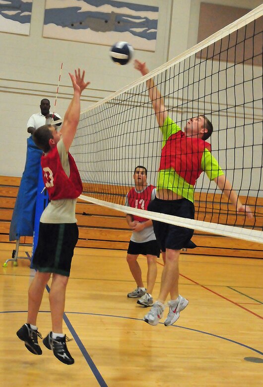 Air Force Capt. Clayton White, right, tips the ball back over the net as an opponent with the 628th Communication Squadron jumps to block during the Commander's Cup volleyball challenge at the Fitness and Sports Center on Joint Base Charleston, S.C., Sept. 30, 2010. The game was played between the 14th Airlift Squadron and 628th Communications Squadron. The 14 AS won two consecutive matches with close scores of 25-20 and 25-19. The game was part of a weeklong series of sporting events leading up to JB CHS's full operating capability inauguration Oct. 1, 2010. Captain White is with the 14 AS. (U.S. Air Force photo/Staff Sgt. Daniel Bowles.)