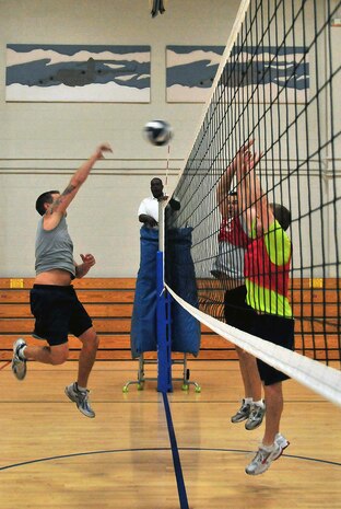 An Air Force member of the 628th Communication Squadron spikes the ball over the heads of opponents from the 14th Airlift Squadron during the Commander's Cup volleyball challenge at the Fitness and Sports Center on Joint Base Charleston, S.C., Sept. 30, 2010. The game was part of a weeklong series of sporting events leading up to JB CHS's full operating capability inauguration. Sporting events preceding the volleyball challenge were golf, bowling and basketball, followed by bike, run and swim relay challenges held on the Oct. 1, 2010, inaugural day. (U.S. Air Force photo/Staff Sgt. Daniel Bowles.)