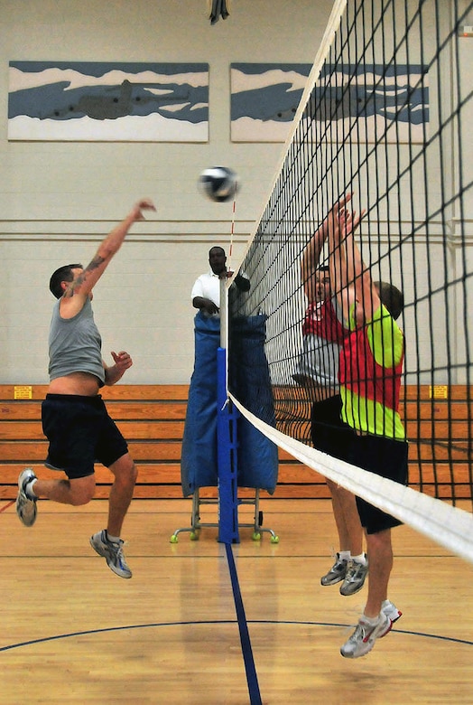 An Air Force member of the 628th Communication Squadron spikes the ball over the heads of opponents from the 14th Airlift Squadron during the Commander's Cup volleyball challenge at the Fitness and Sports Center on Joint Base Charleston, S.C., Sept. 30, 2010. The game was part of a weeklong series of sporting events leading up to JB CHS's full operating capability inauguration. Sporting events preceding the volleyball challenge were golf, bowling and basketball, followed by bike, run and swim relay challenges held on the Oct. 1, 2010, inaugural day. (U.S. Air Force photo/Staff Sgt. Daniel Bowles.)