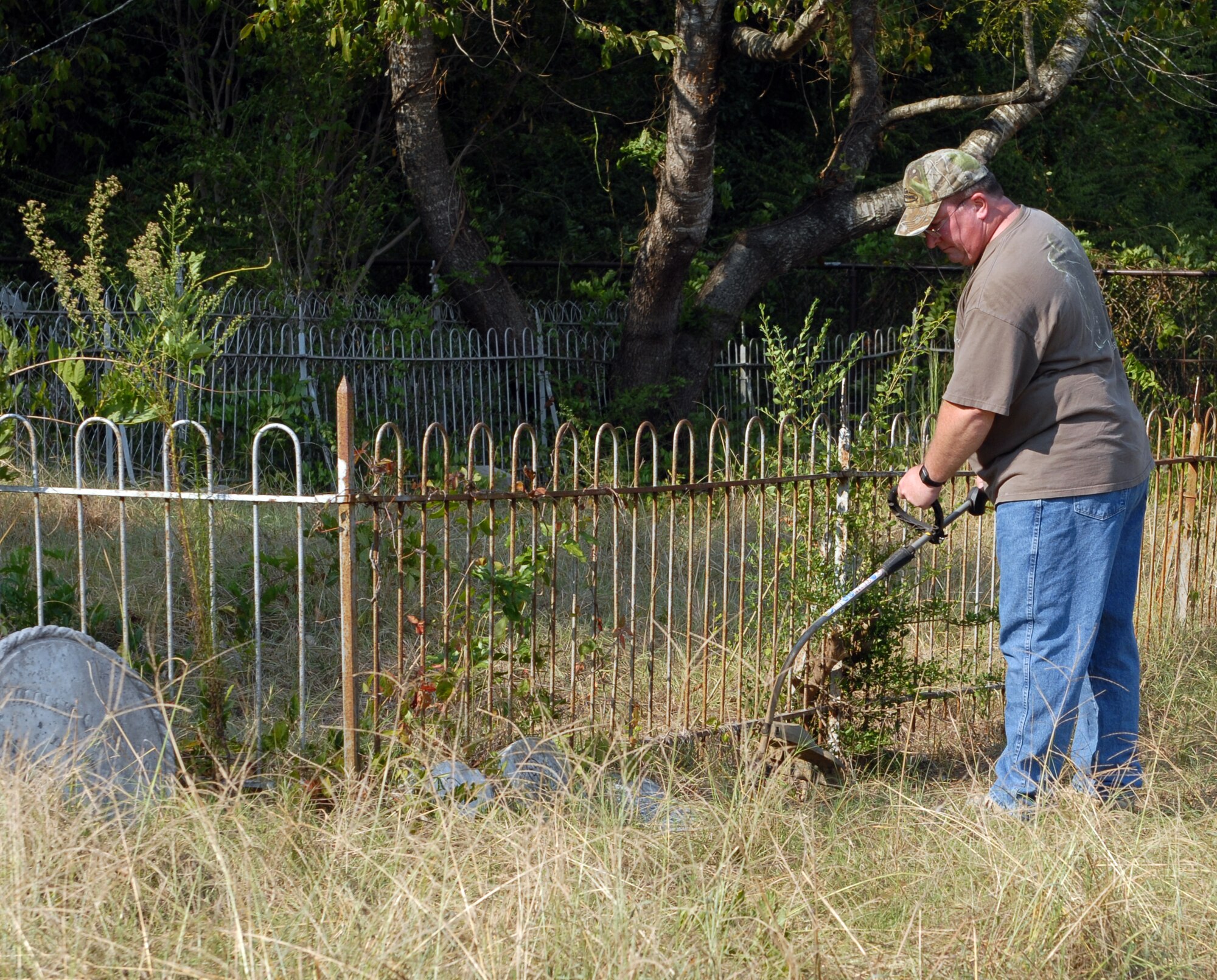 Larry Caldwell, 14th Mission Support Group logistics readiness division deputy, works to clean up the Greer-Rush-Nelson Burying Ground Sept. 21. The graveyard is the only piece of land on base not owned by the federal government, and as such cannot be maintained with base resources. Because of this the site depends on the actions of volunteers such as Mr. Caldwell to help keep from fading into the past. (U.S. Air Force photo/Clara Whitley).
