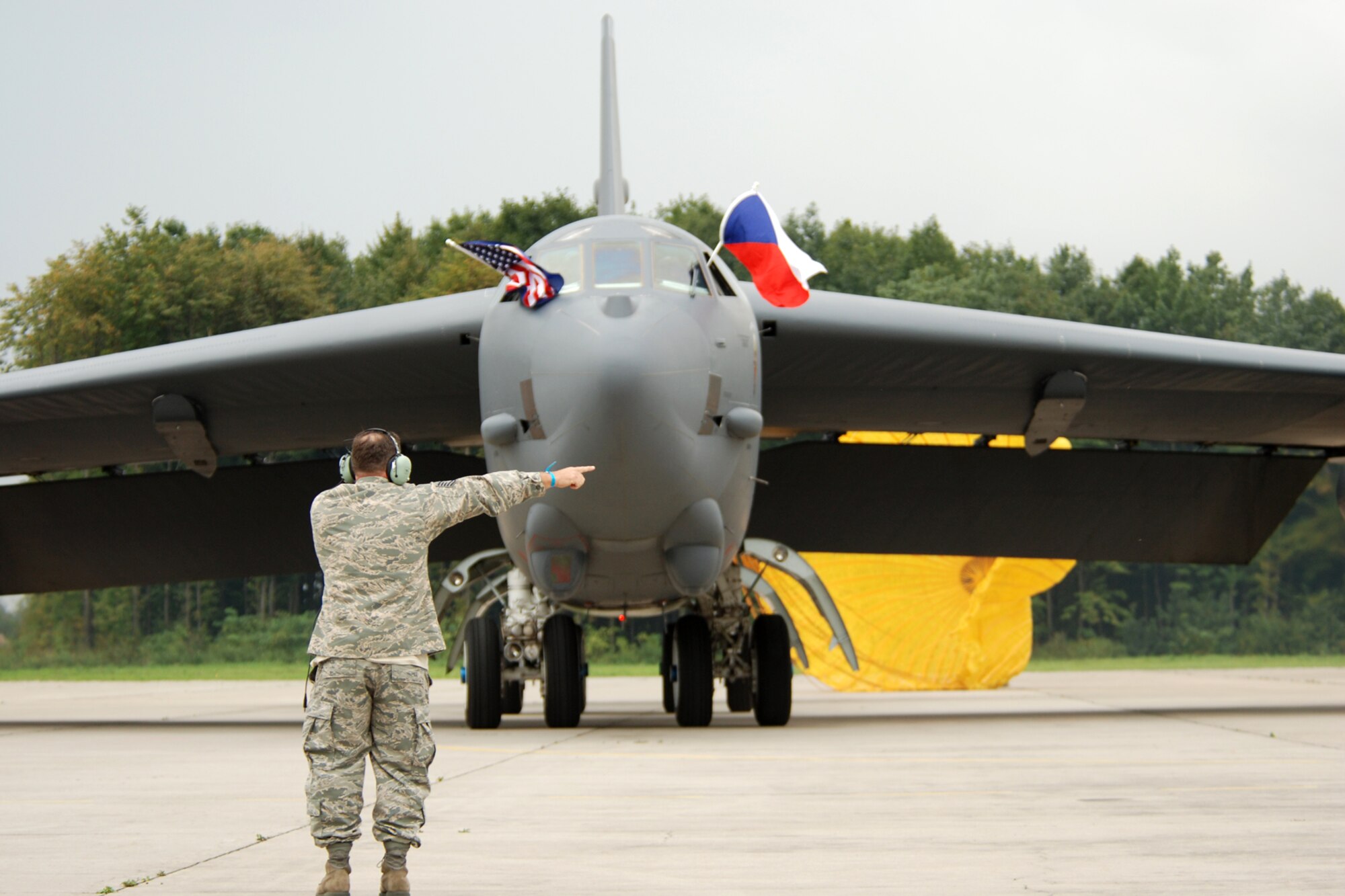 Technical Sgt. David Johnson, 917th Aircraft Maintenance Squadron crew chief, signals to the pilot as he “hands off” the final aircraft marshalling to the lead crew chief of a B-52 Stratofortress displaying the United Sates, NATO and Czech Republic flags from the cockpit windows at the Leos Janacek Ostrava Airport, Ostrava, Czech Republic, Sept. 15, 2010. The landing marked the first ever for a B-52 in the Czech Republic. The historic flight was made to the Czech Republic in support of the 10th NATO Days in Ostrava & 1st Czech Air Force Days Air Show, which is scheduled for Sept 18-19, 2010. The B-52 Stratofortress, its crew and support personnel are from the 917th Wing and 93rd Bomb Squadron at Barksdale Air Force Base, La. (U.S. Air Force photo/Master Sgt. Greg Steele) 