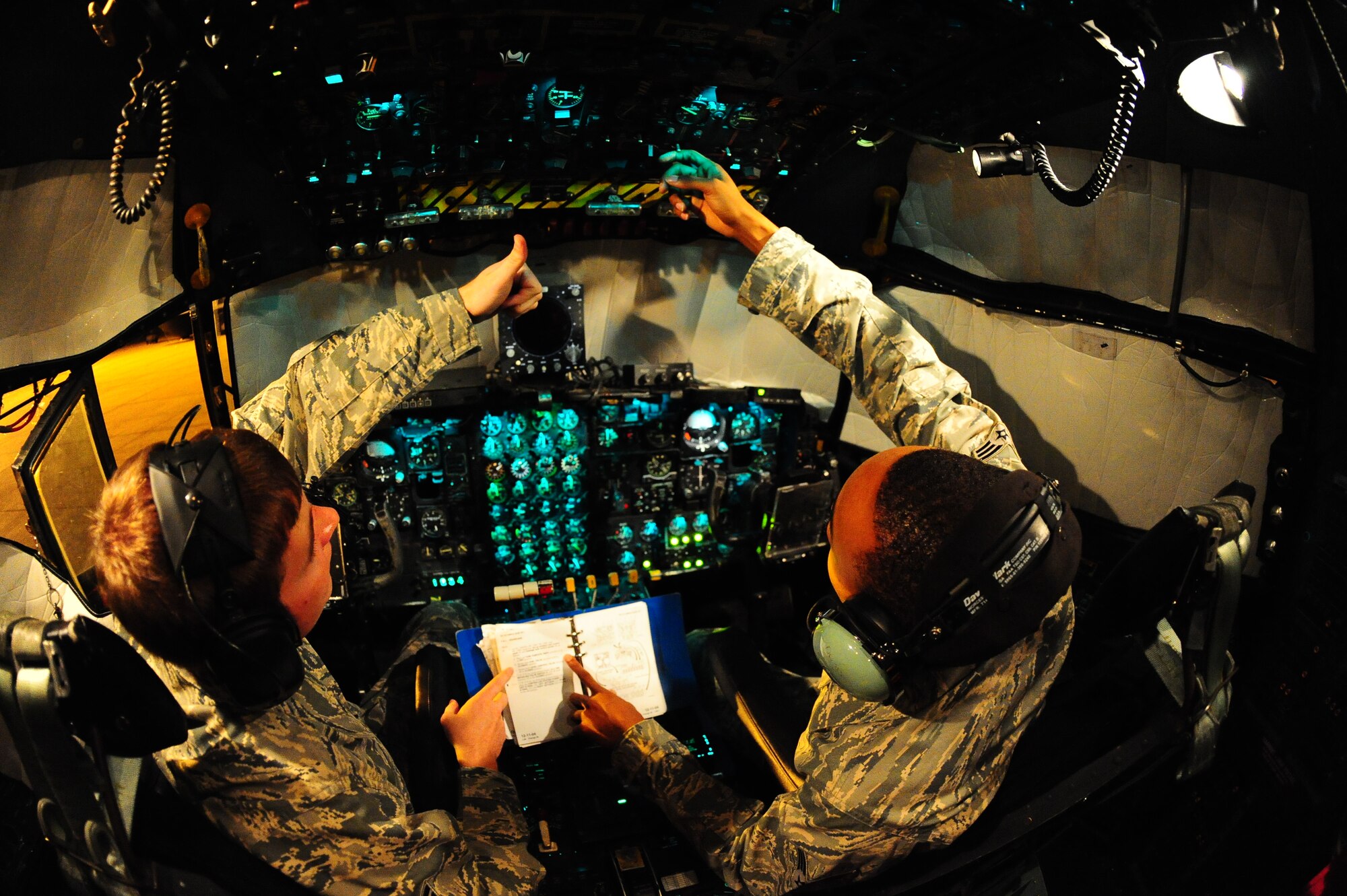DYESS AIR FORCE BASE, Texas—Senior Airmen David Ragsdale (left) and Billy Pryor (right), 317th Maintenance Squadron fuel systems repair, look through a training guide while refueling a C-130 Hercules here, Sept. 28. Both Airmen work through the night to make sure planes are adequately fueled for their next flight. This is mission essential due to the many hours planes spend in the air carrying troops, equipment and cargo to wherever needed. (U.S Air Force photo/ Airman 1st Class Shannon Hall)