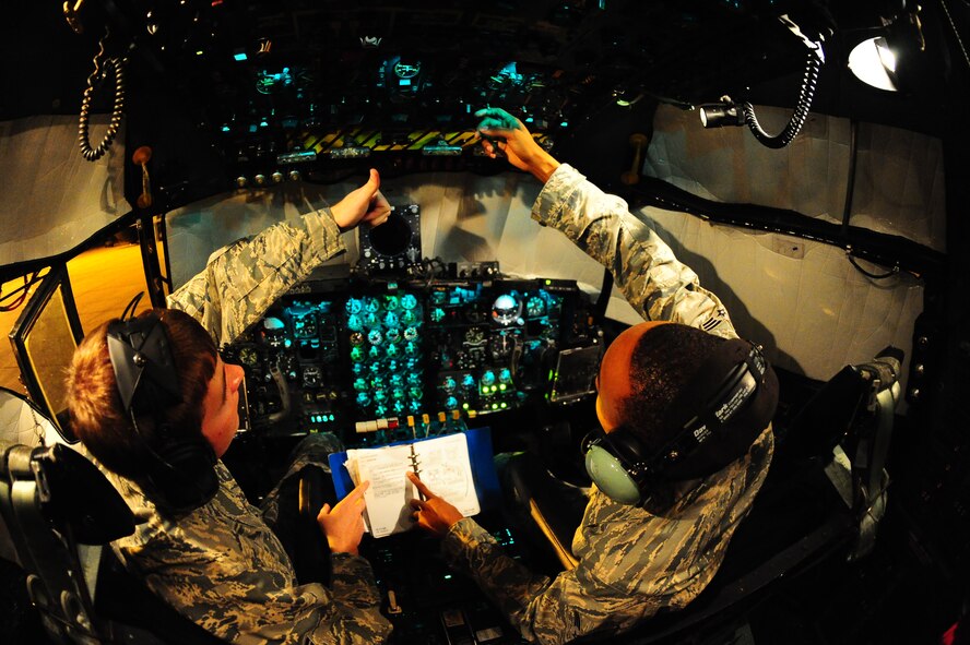 DYESS AIR FORCE BASE, Texas—Senior Airmen David Ragsdale (left) and Billy Pryor (right), 317th Maintenance Squadron fuel systems repair, look through a training guide while refueling a C-130 Hercules here, Sept. 28. Both Airmen work through the night to make sure planes are adequately fueled for their next flight. This is mission essential due to the many hours planes spend in the air carrying troops, equipment and cargo to wherever needed. (U.S Air Force photo/ Airman 1st Class Shannon Hall)
