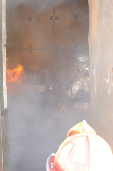 DYESS AIR FORCE BASE, Texas—Staff Sgt. Daniel Newland, 7th Civil Engineer Squadron firefighter, puts out flames during a training exercise here, Sept. 30.  The squadron has more than 55 firefighters and operates more than 15 fire trucks. Some days the station gets up to ten calls and the firefighters are required to be on scene within five minutes of the call. They conduct routine safety checks on buildings as well as practice procedures in case of a fire.  (U.S Air Force photo/ Airman 1st Class Shannon Hall)
