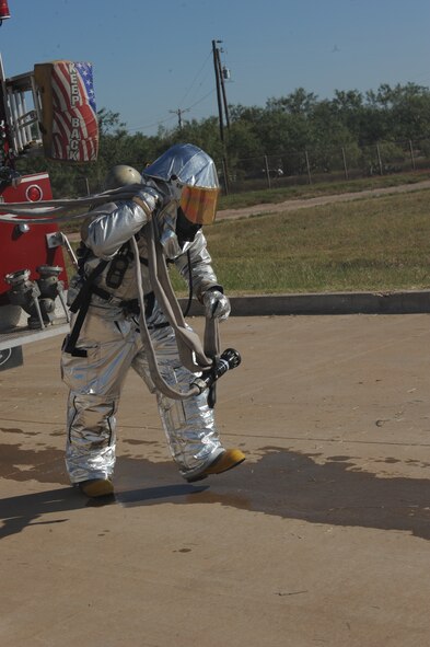 DYESS AIR FORCE BASE, Texas—Airman Tyler Ellie, 7th Civil Engineer Squadron firefighter, unwinds a water hose from a fire truck during a training exercise here, Sept. 30. The squadron has more than 55 firefighters and operates more than 15 fire trucks. Some days the station gets up to ten calls and the firefighters are required to be on scene within five minutes of the call. They conduct routine safety checks on buildings as well as practice procedures in case of a fire. (U.S Air Force photo/ Airman 1st Class Shannon Hall)   