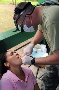 AGUA SALADA, Honduras --  Lt. Col. Thomas Edmonson, who works with the Joint Task Force-Bravo Medical Element, works to extract the tooth of a woman here during the medical readiness training exercise Sept. 28. Dental technicians from MEDEL, the Honduran military and the local area treated 75 patients throughout the two-day mission. (U.S. Air Force photo/Tech. Sgt. Benjamin Rojek)