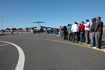Patrons line up for the C-17 Globemaster III static display at the Africa Aerospace and Defense Expo, Sept. 25 at Ysterplaat Air Force Base Cape Town, South Africa. A Reserve aircrew from the 317th Airlift Squadron Charleston Air Force Base, South Carolina introduced the C-17 to thousands of visitors over the five day trade and air show.