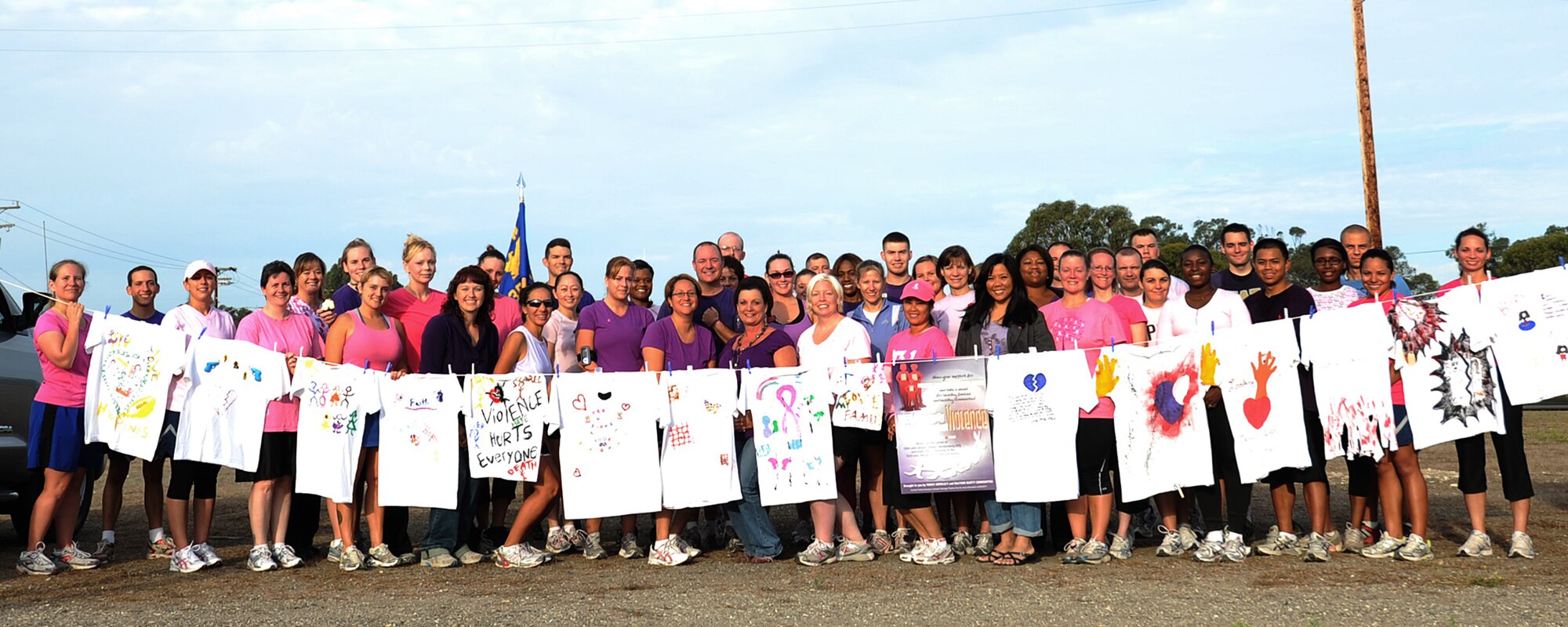 VANDENBERG AIR FORCE BASE, Calif. -- Showing off their pink and purple shirts, members of Team V stand together in front of the Clothesline Project after the Fit-to-Fight Run here Thursday, Sept. 30, 2010. The Clothesline Project was made of shirts that were designed by women affected by domestic violence and were displayed as a testimony to the problem of violence against women. (U.S. Air Force photo/ Senior Airman Ashley Reed)