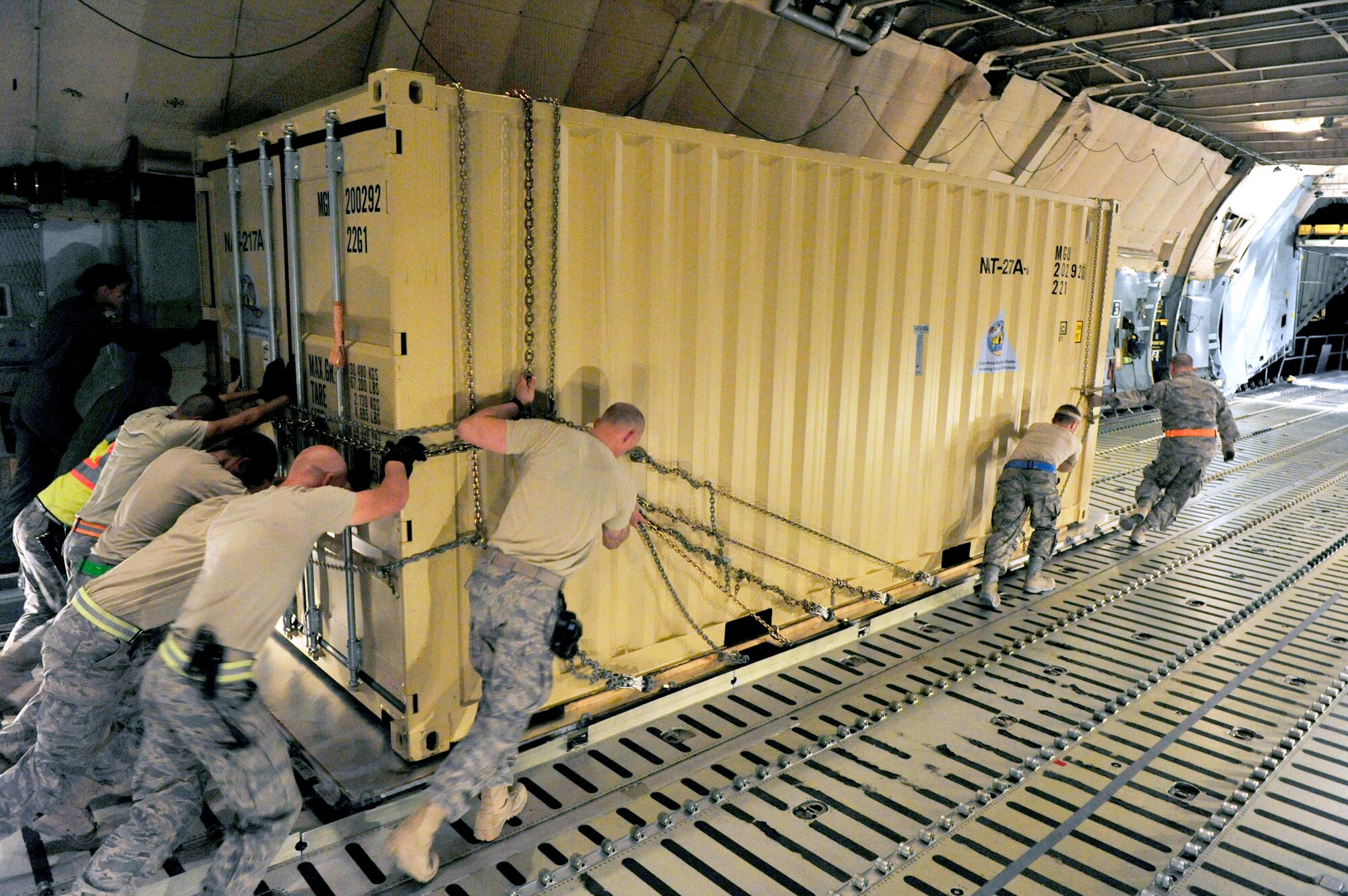 Airmen from the 621st Contingency Response Wing at Joint-Base McGuire-Dix-Lakehurst, N.J., push a prefabricated shelter facility from a C-5B Galaxy onto a waiting 60k cargo loader July 1, 2010 at Camp Marmal, Afghanistan. Thousands of tons of supplies have been processed in the past few weeks by teams of CRW Airmen as forces called up by the presidentially-directed surge of manpower and equipment have been arriving into Afghanistan. (U.S. Air Force photo/Tech. Sgt. Parker Gyokeres)
